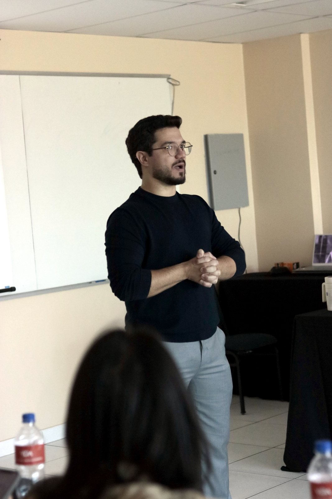 Caio Benevides explicando em frente ao quadro durante a formação